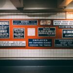 a subway station with a bunch of signs on the wall