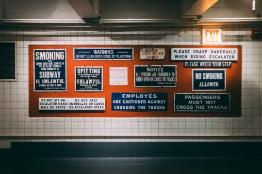 a subway station with a bunch of signs on the wall
