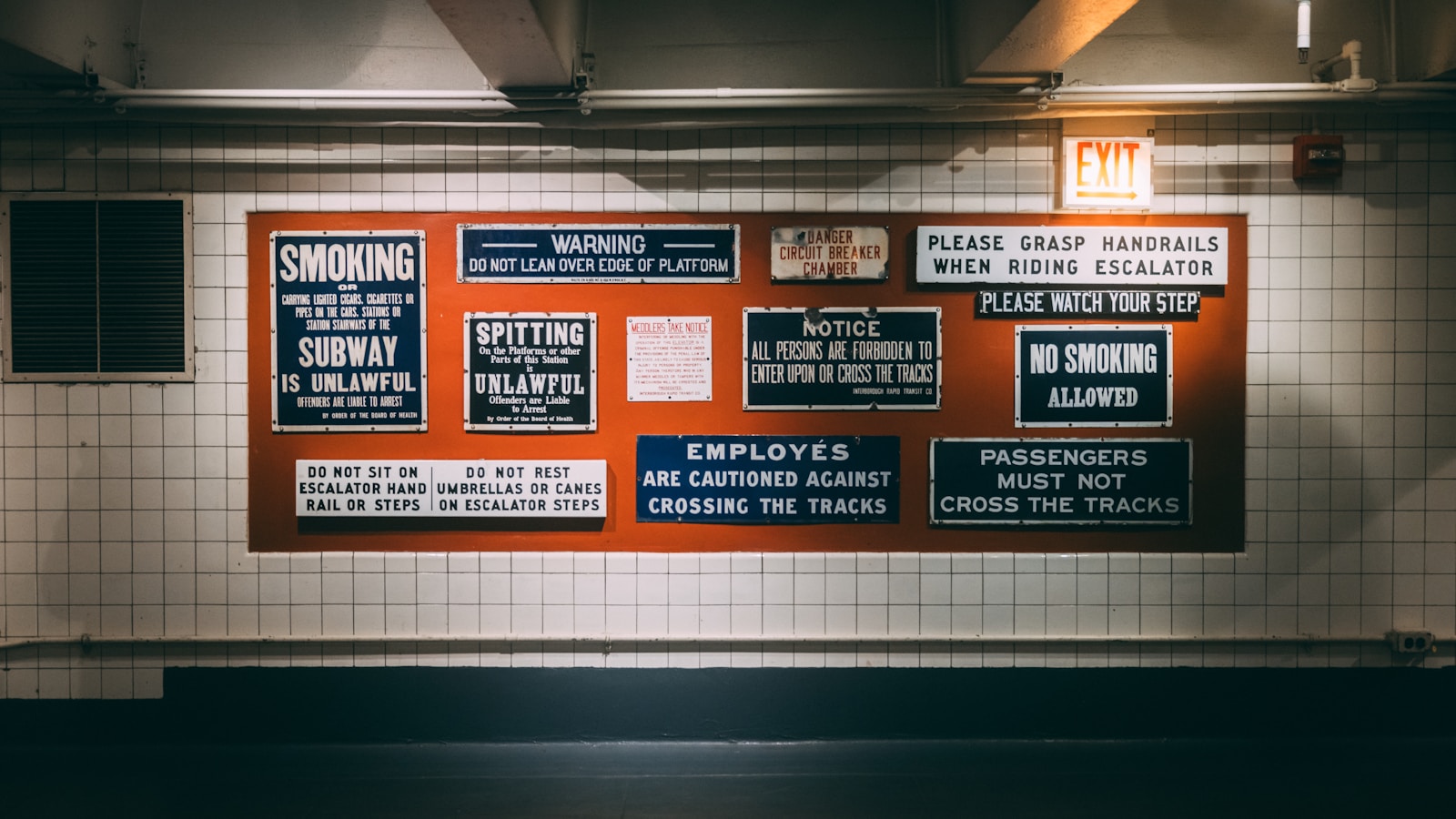 a subway station with a bunch of signs on the wall