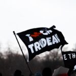 a group of people holding a black and white flag