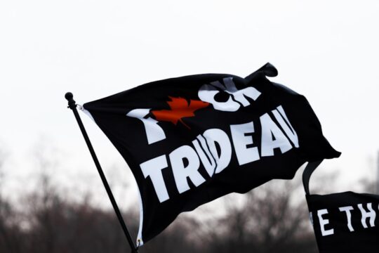 a group of people holding a black and white flag
