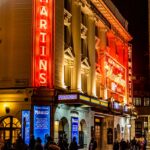 people walking on street near brown concrete building during nighttime