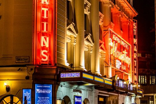 people walking on street near brown concrete building during nighttime