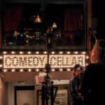 people standing outside of a building with a sign that says comedy cellar