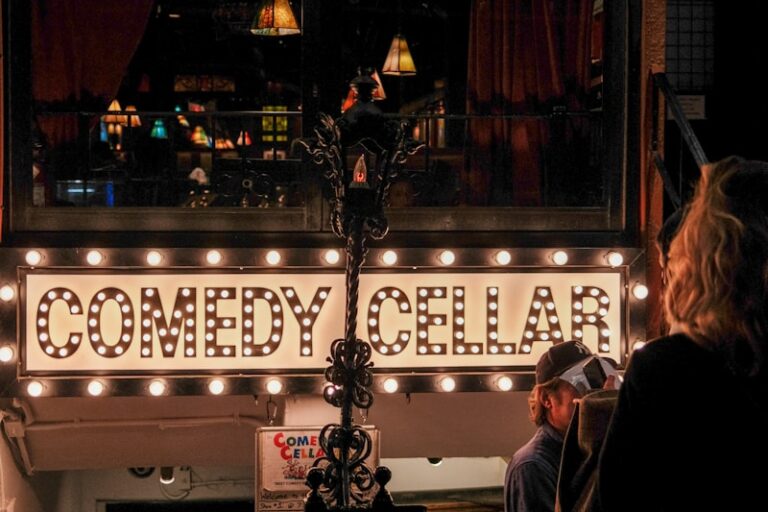 people standing outside of a building with a sign that says comedy cellar