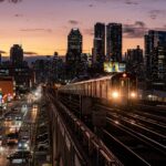 cars on road between high rise buildings during night time