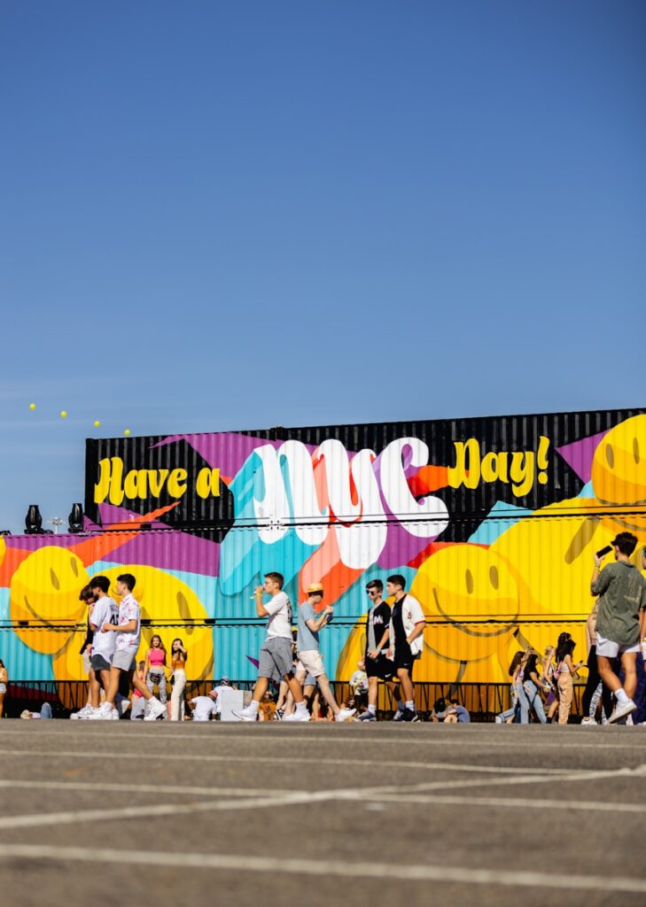 a group of people walking in front of a colorful wall